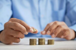 Person stacking coins on table