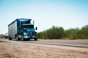 Blue truck driving along rural road