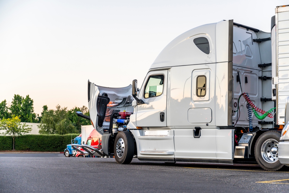 White big rig semi truck with open hood for engine inspection st