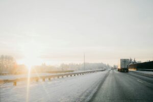 truck driving along snowy road in the winter