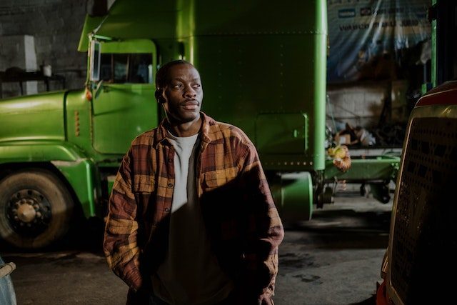 Man Standing Near the Green Truck