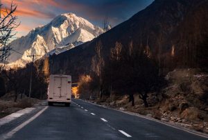 White bus on road near mountain