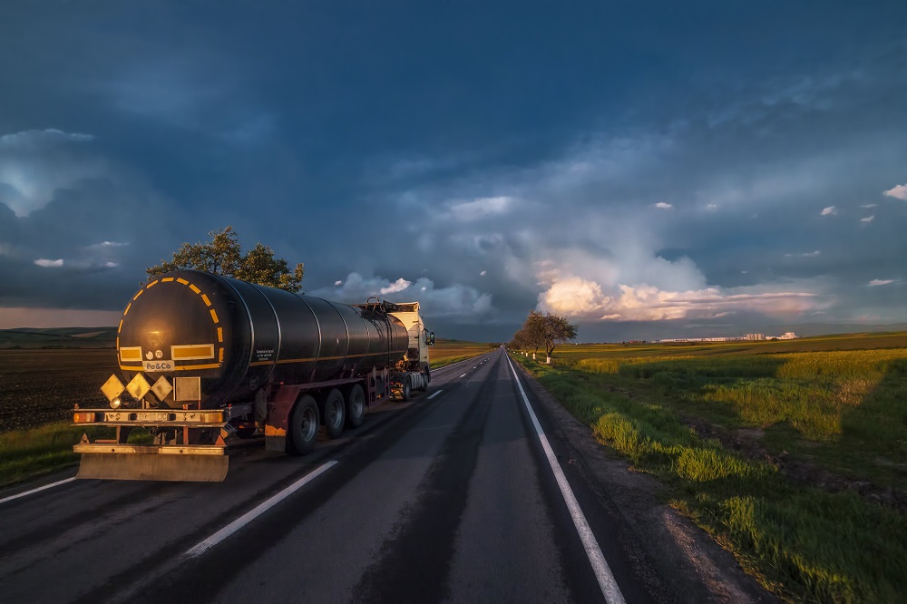 Yellow and black truck on road under blue sky