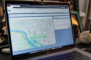 Laptop screen displaying a GPS tracking map with a fleet location marked