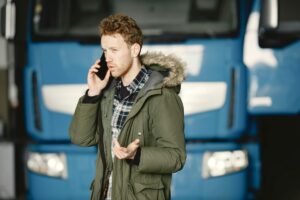 Man on phone in front of blue truck