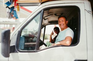 Truck driver giving a thumbs up from the cab of his truck at a fuel stop