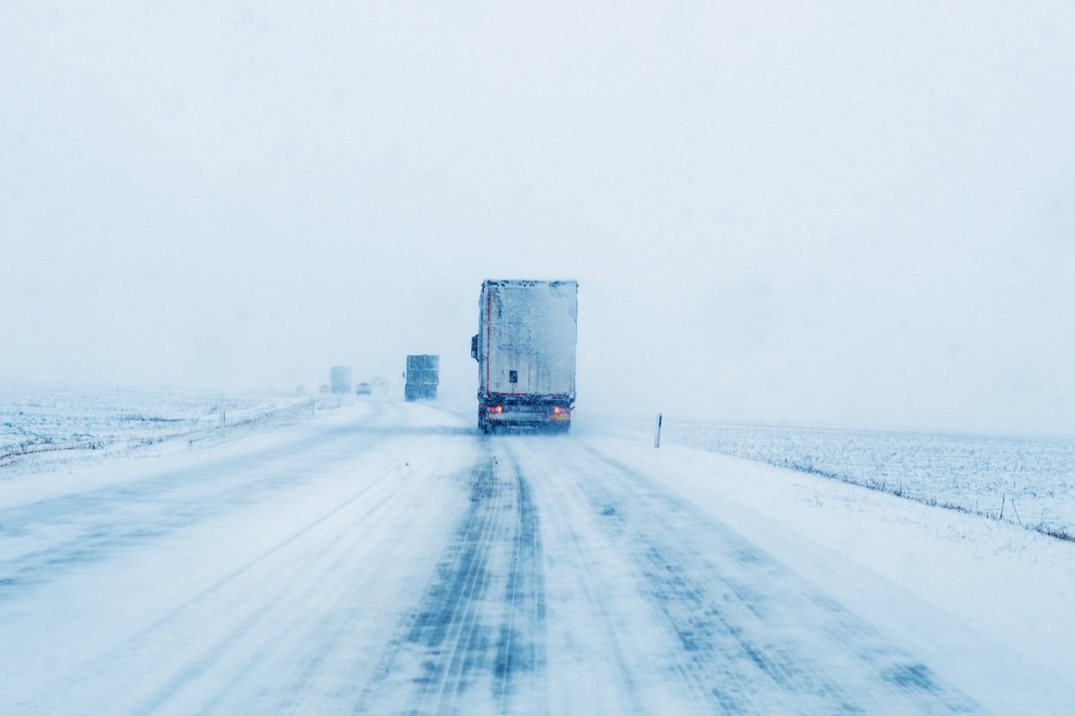 Freight transportation truck on the road in snow storm blizzard