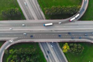 Aerial view of roads with cars and trucks driving along them.