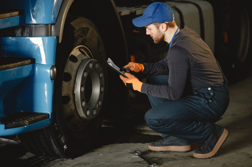 man conducting a pre-trip inspection of his truck