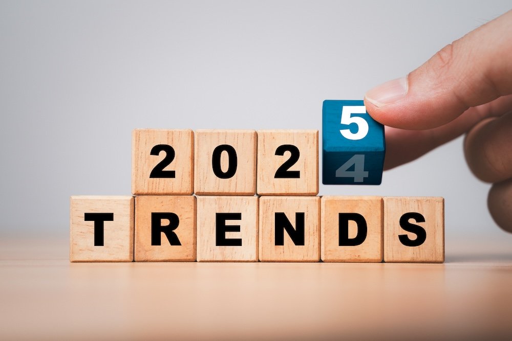 Hand flipping wooden block cube to change from 2024 to 2025 trends for business , fashion and technology trend change concept after new year.
