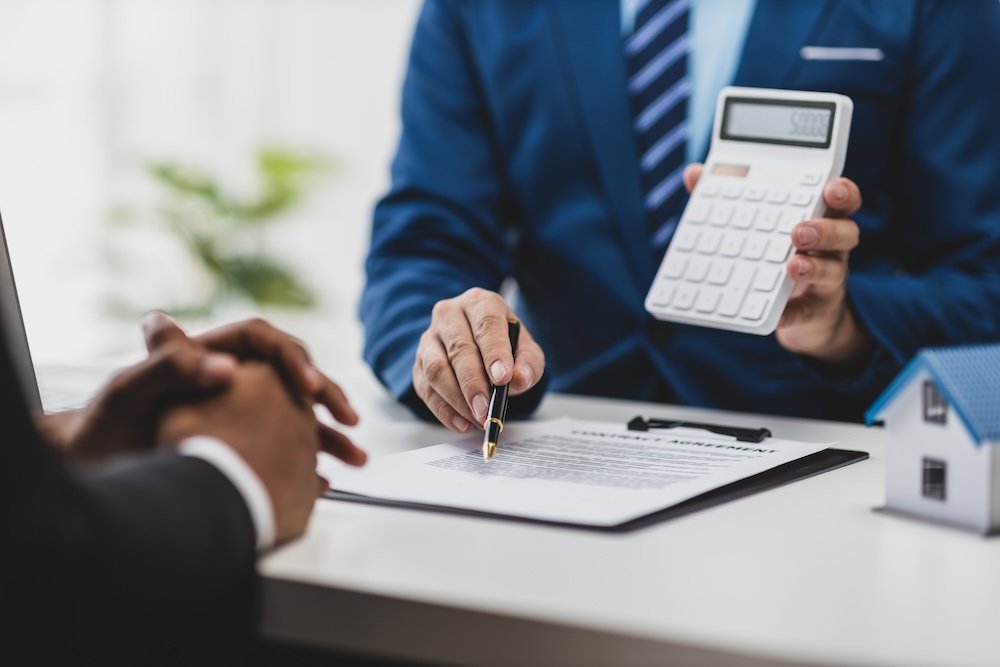 Businessman, real estate agents discuss house sale prices, fee, mortgage, interest, rent, cash flow, loan. Businessman is offering a house price to a customer.
