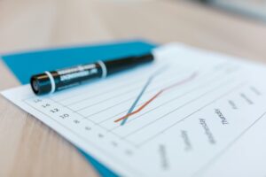 report graph resting on a desk below a black marker