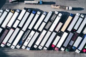 aerial view of dozens of parked commercial trucks in a depot