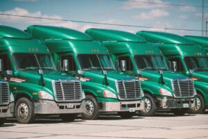 row of parked green commercial trucks