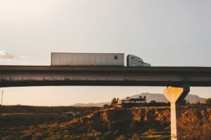 white commercial freight truck crossing a high bridge