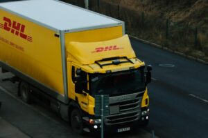 Yellow DHL truck driving on road