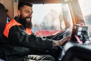 Young worker driving a waste truck