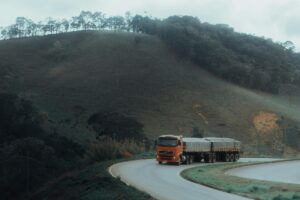 truck driving on road against hillside