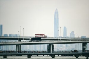 truck driving on elevated road against city in the distance