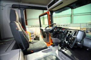 Interior of a new model of a dump truck Scania cabin: seat, wheel, dashboard.