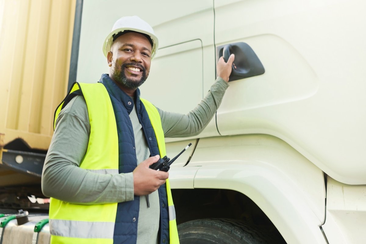 Truck driver, black man and export logistics manager working in industrial shipping yard, manufacturing industry and transport trade. Portrait, delivery truck cargo and happy distribution courier job