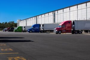 Logistics warehouse exterior with loading bays and trucks.