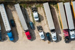 Semi trucks and trailers parked on an unpaved lot for commercial logistics and cargo transport