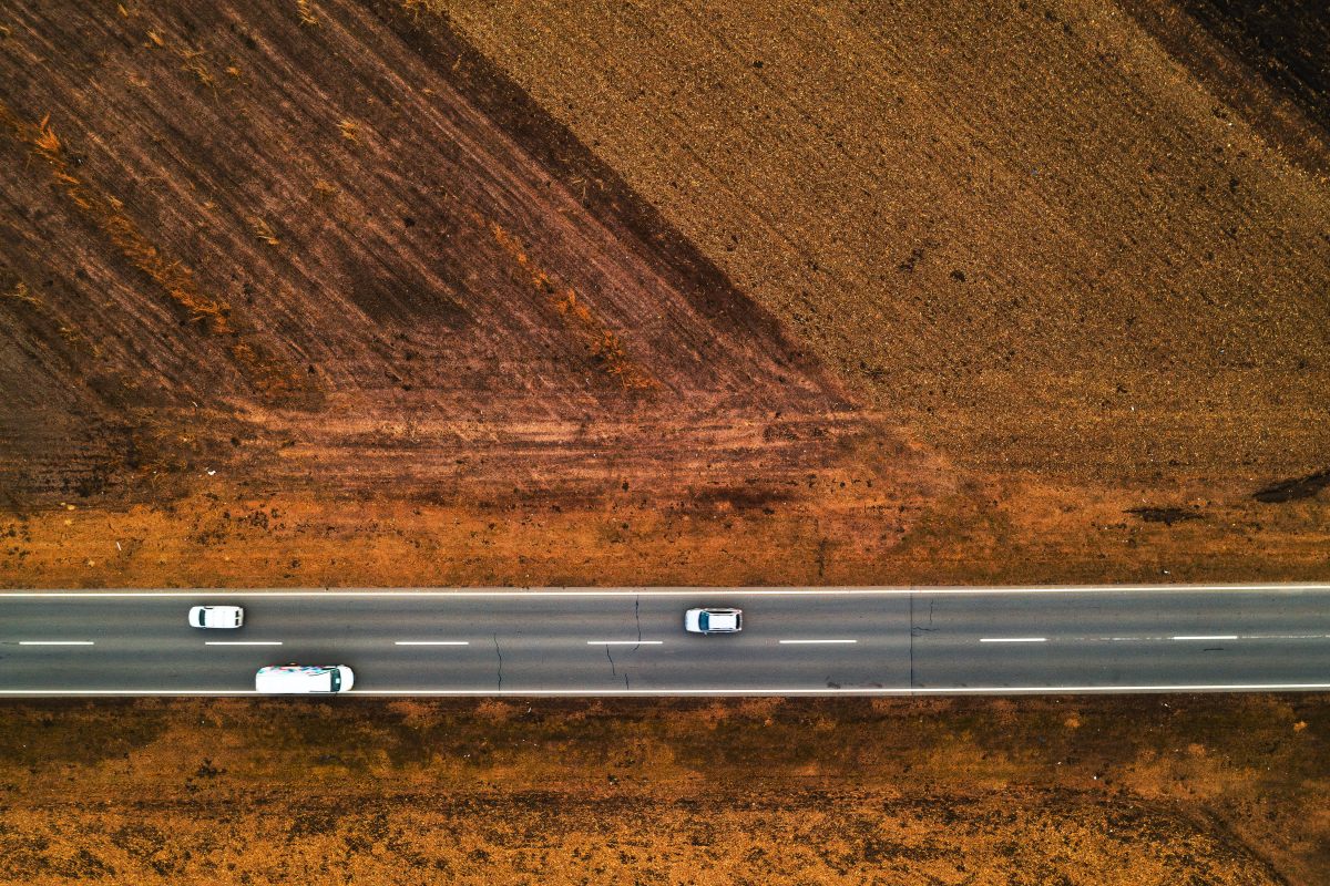 Cars and trucks on the road through countryside, aerial view