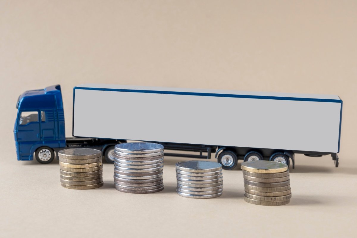 Mock-up of tractor-trailer, coins placed on light background. Concept. Tariffs, calculation, freight transport costs by truck.