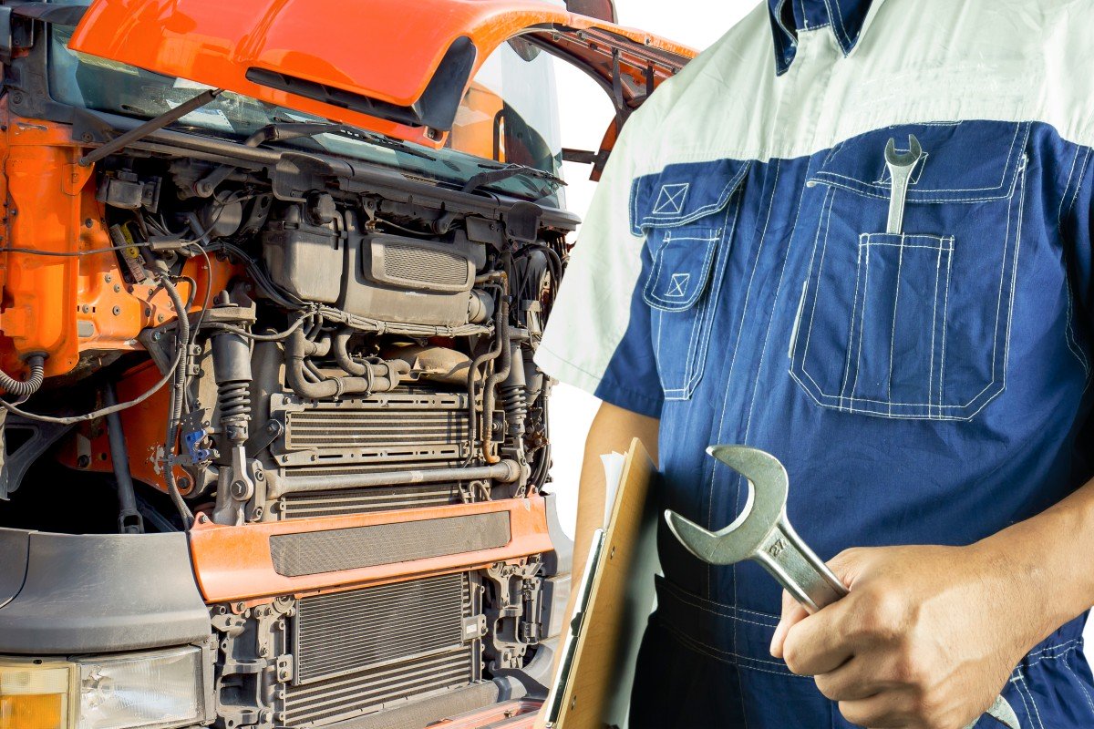 Truck maintenance and repairing. Professional auto mechanic holding wrench is maintenance the engine semi truck.