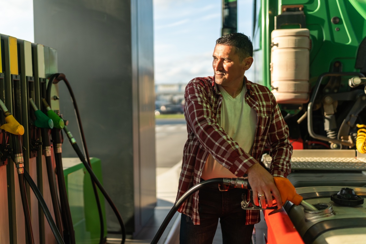 a truck driver fills his tank with fuel before continuing on his route, after a break at a gas station