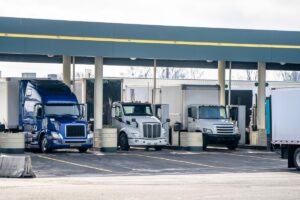 Semi Trucks with different semi trailers of various brands and models fill the tanks at the filling station