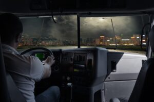 the driver is a truck with a load in the night city. business trip