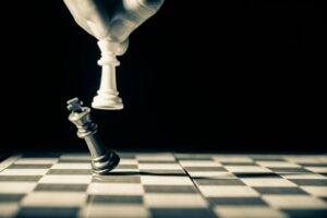 Chess piece knocking down king, symbolizing risk management strategy
