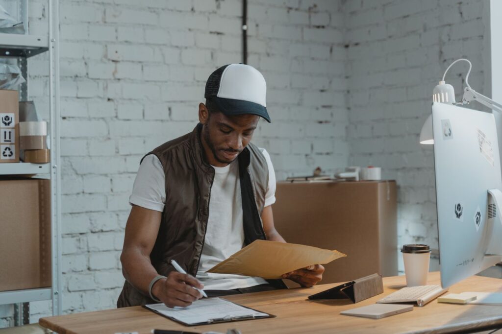 Trucking business owner reviewing paperwork and filling out a financing application at a desk
